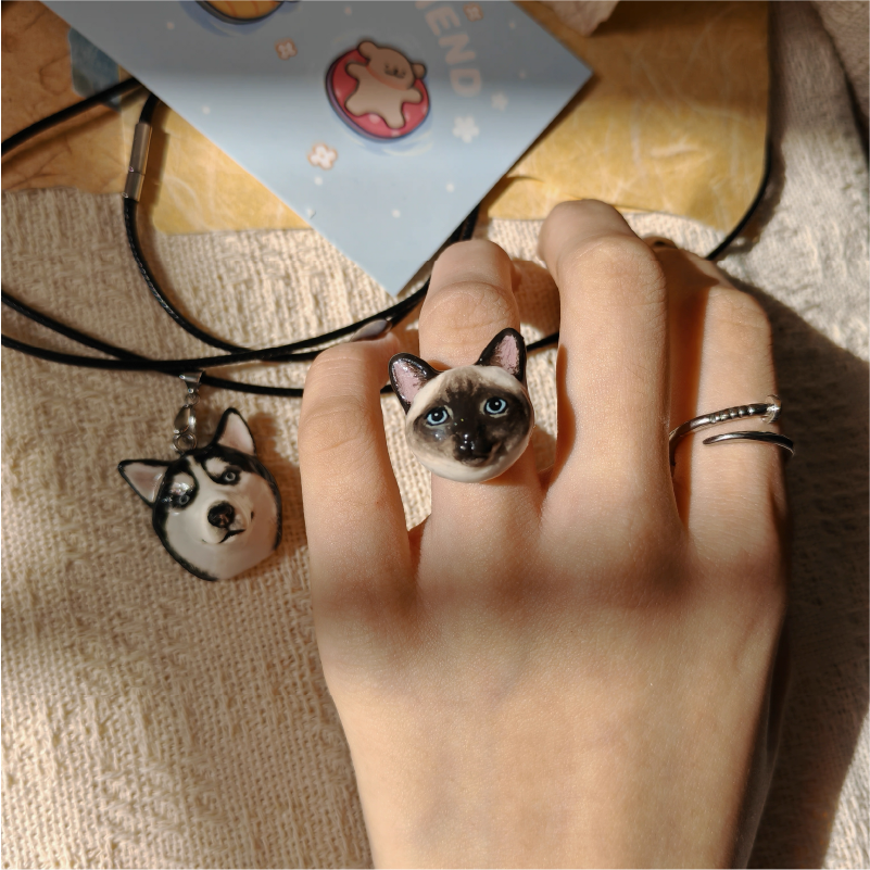 Custom pet plaster necklace pair shown in hand